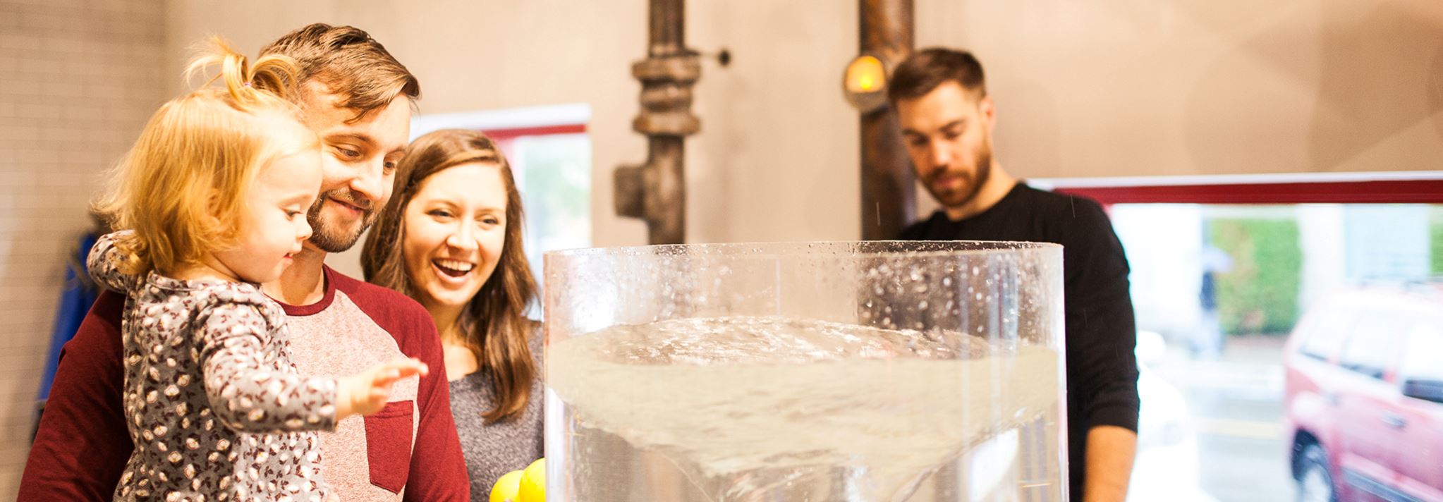Parents and a child looking at a water exhibit.